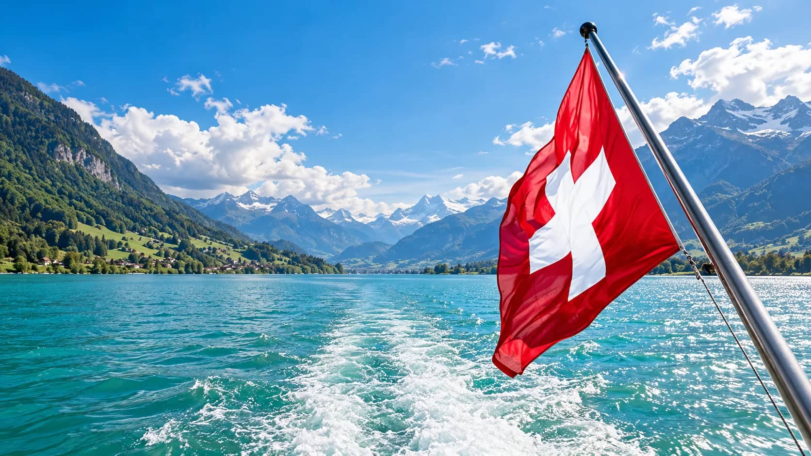 Drapeau suisse à la poupe d’un bateau sur un lac de montagne, les Alpes en arrière-plan.